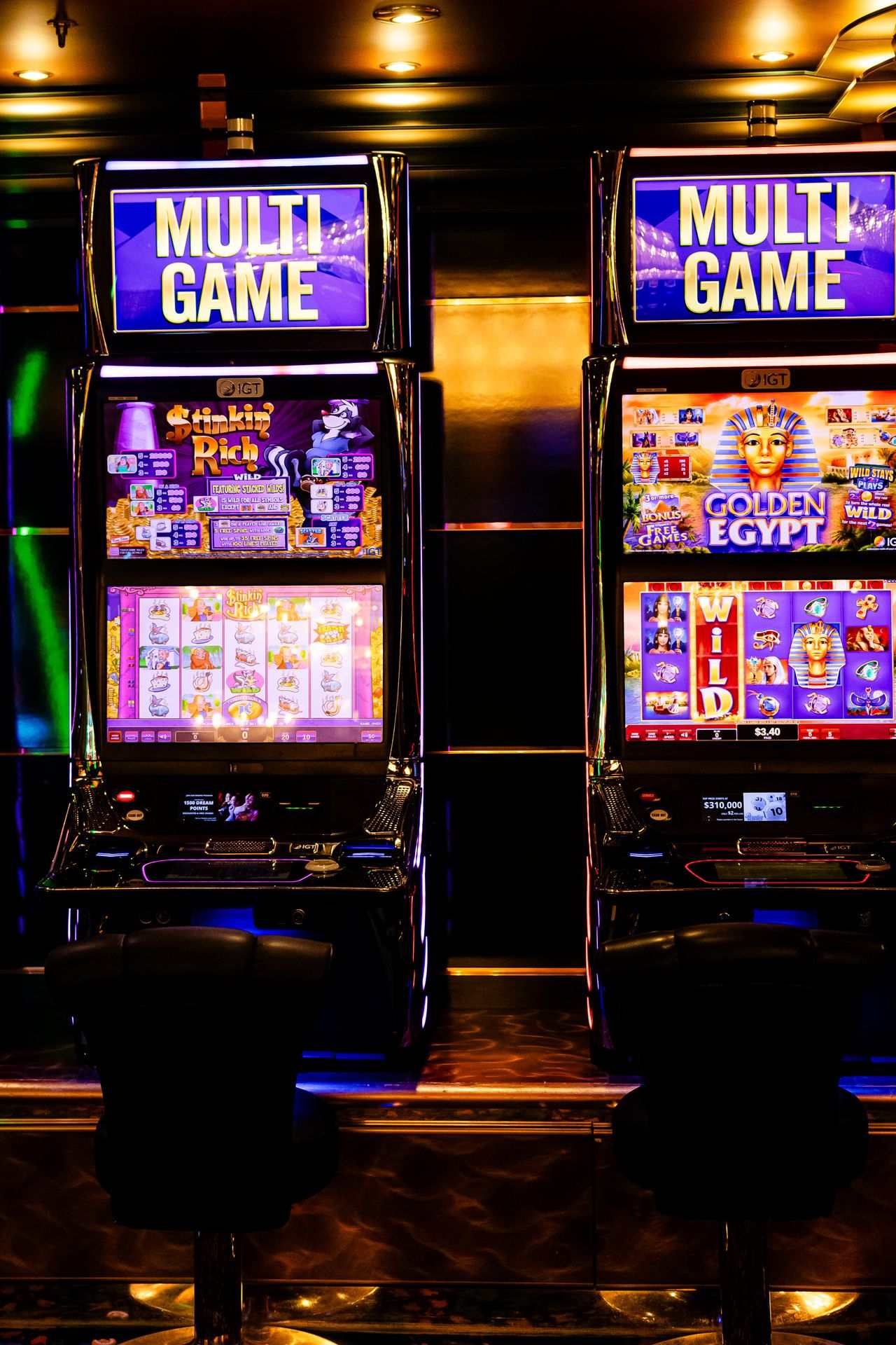 Dua mesin slot multi permainan menyala di kasino yang temaram