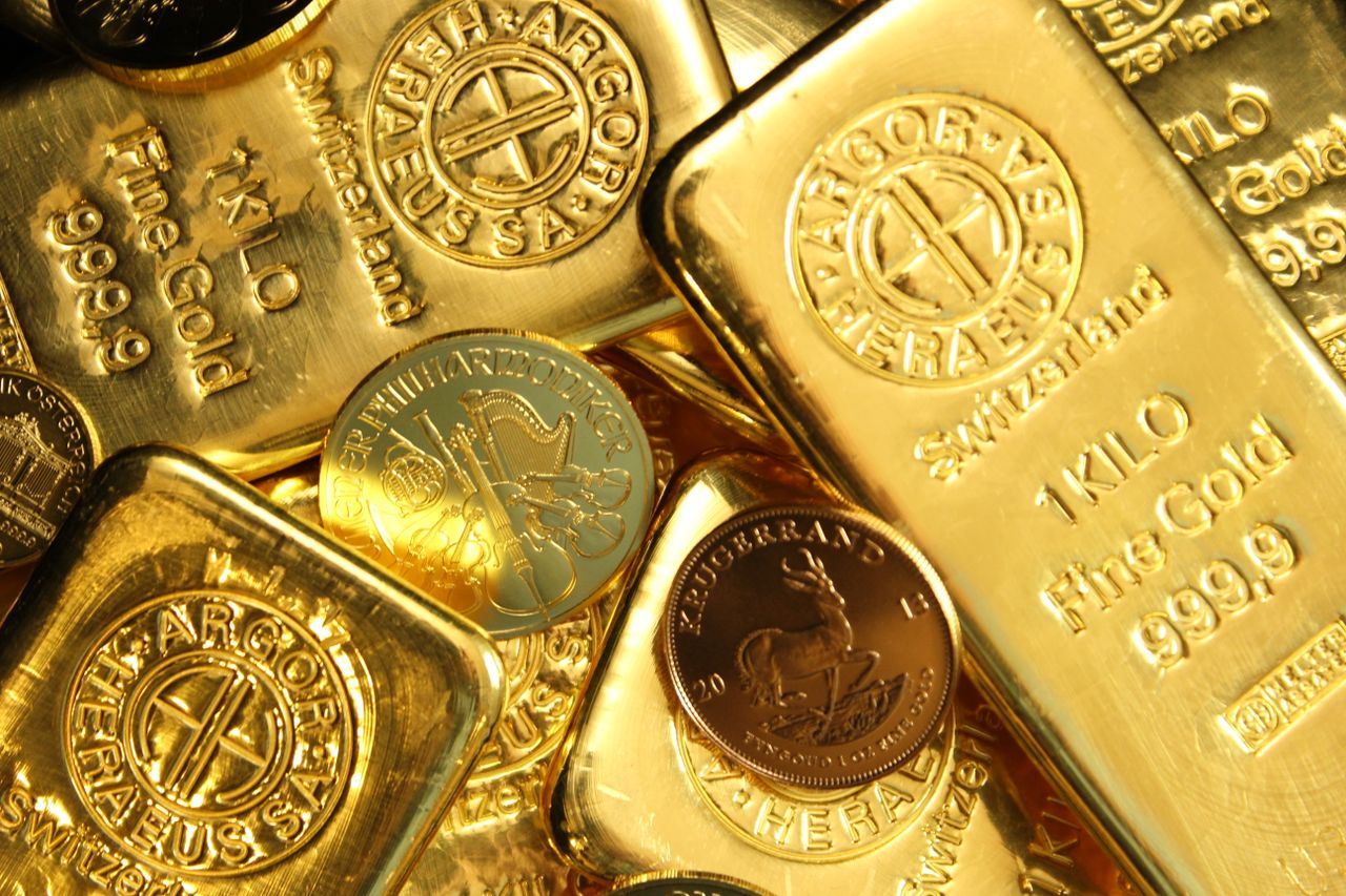 Batangan dan koin emas bertumpuk dengan tulisan fine gold
