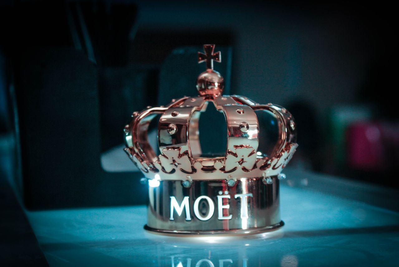 Mahkota logam berwarna rose gold di atas tumpukan batu